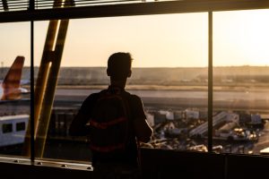 A traveler walks through an airport terminal, reflecting the movement of people across borders for work and new opportunities. Photo: Magnific/HelloDavidPradoPerucha