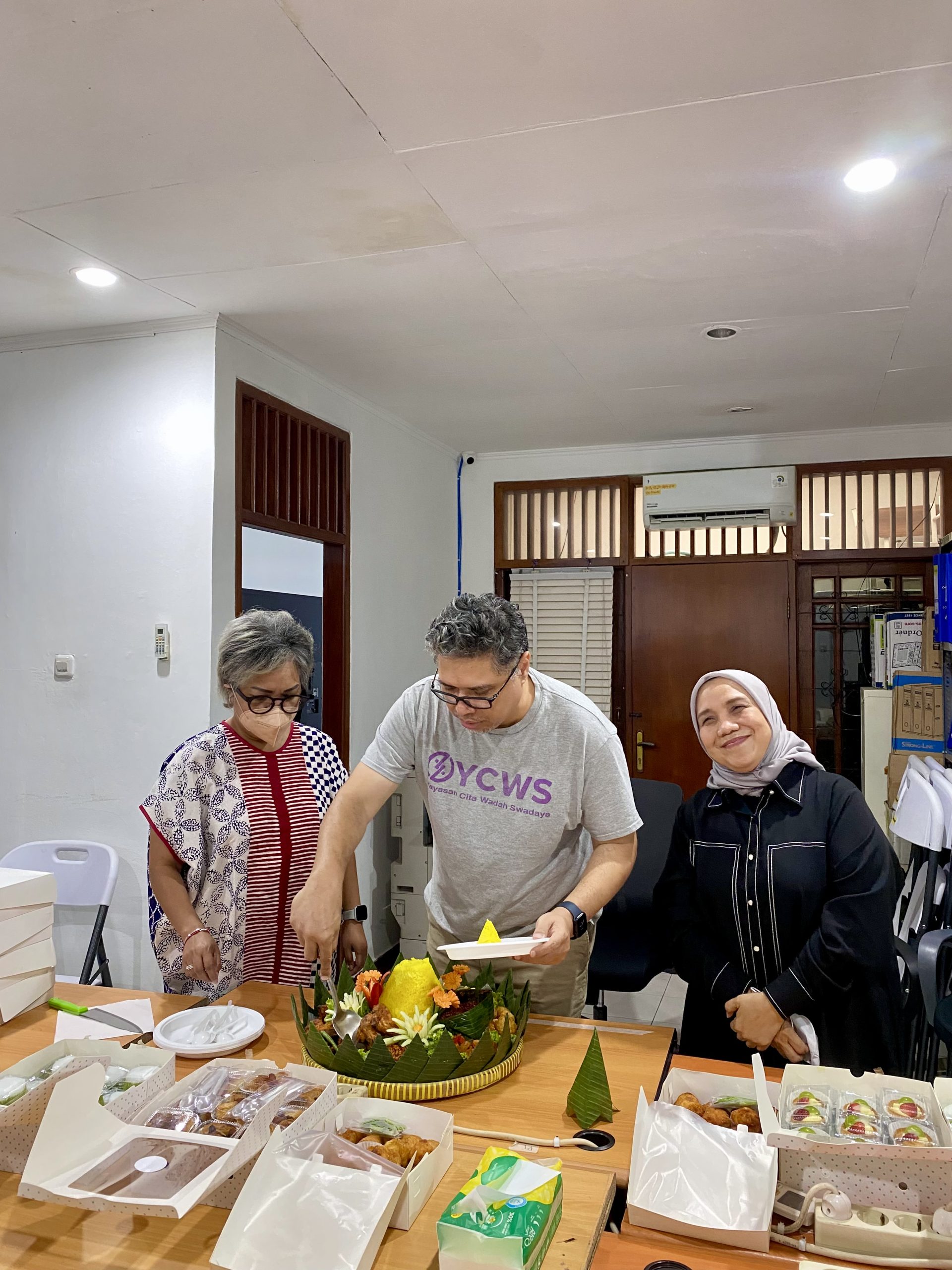 YCWS Executive Director Dino Satria cuts the tumpeng during a gathering and celebration marking YCWS’s second anniversary. Doc/YCWS.